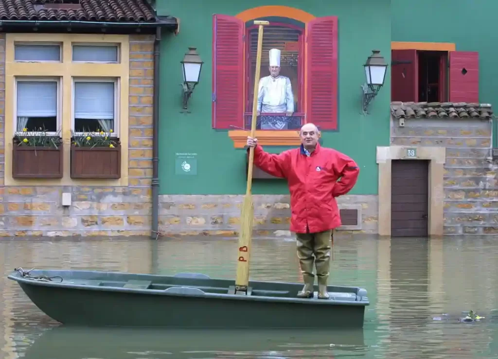 洪水浸水中のレストランと船に乗るポールボキューズ氏